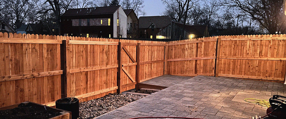 Cedar wood dog ear picket fence along alley at dusk, in Wheat Ridge, Denver, Colorado.