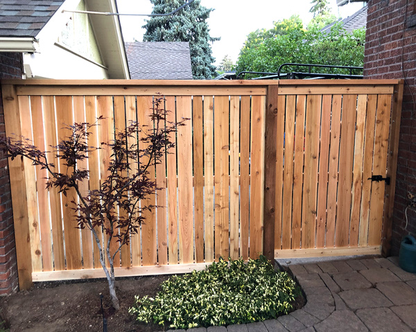 Cedar wood spaced picket fence with top cap and trim board in Congress Park neighborhood in Denver, Colorado.