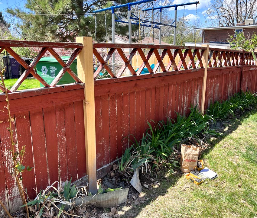 Old red wood fence post repair in Park Hill neighborhood in Denver, Colorado.