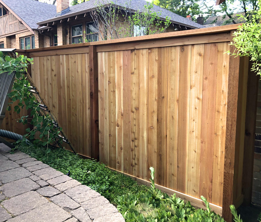 Detail of cedar wood picket fence with top cap and fascia board in Congress Park neighborhood in Denver, Colorado.