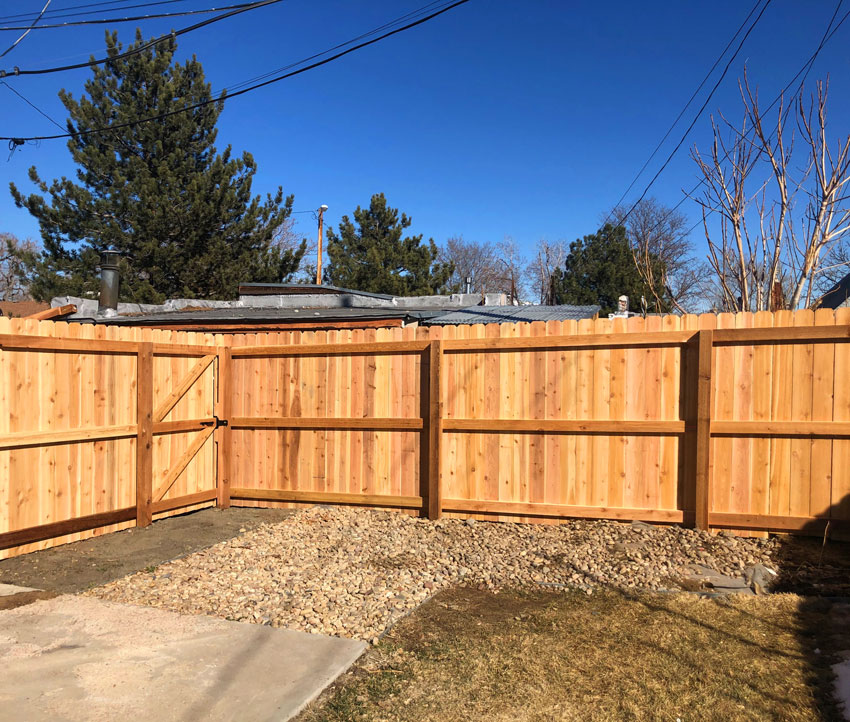 New cedar wood dog ear picket fence with gate in the Sunnyside neighborhood in Denver, Colorado.