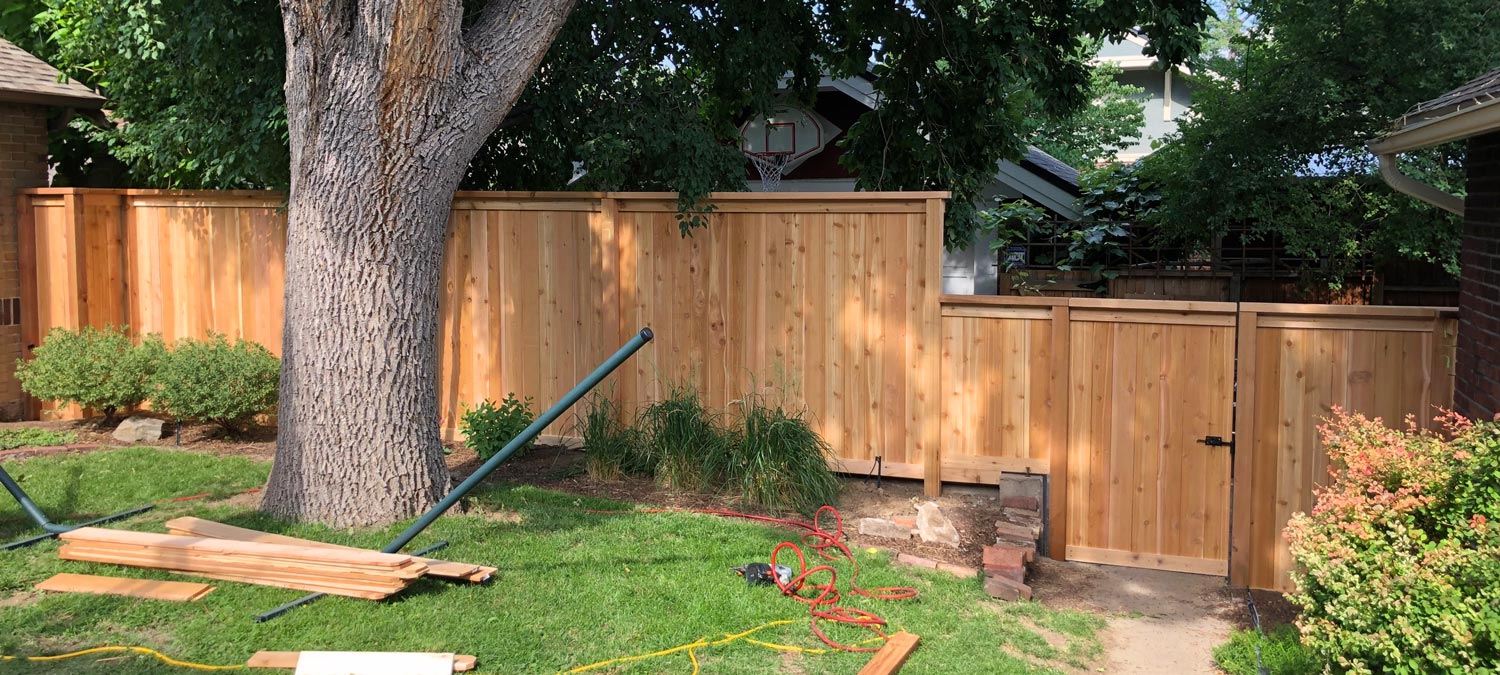 Cedar wood picket fence with top cap and trim board in Congress Park neighborhood in Denver, Colorado.